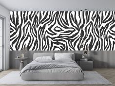 a bedroom with a zebra print wallpaper and bed in the foreground, two nightstands on either side