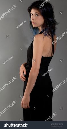 a woman in a black dress posing for the camera with her hand on her hip