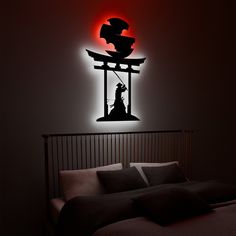 a black and white photo of a bed with a red light on the wall behind it