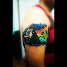 a person with a tattoo on their arm and the image of a dark side of the moon