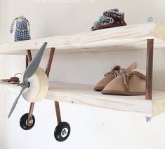 three shelves with shoes and toys on them, one shelf is made out of plywood