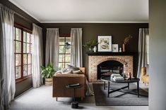 a living room filled with furniture and a fire place in front of a brick fireplace