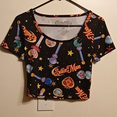 Awesome Sailor Moon Crop Top! The Garment Features Wands, Stars And Sailor Moon Text In An All Over Print. It's Made With 95% Polyester And 5% Spandex. There Are No Flaws To The Shirt. The Measurements Are: Pit To Pit: 15 Inches Length Of Top Of Neckline To Bottom Hem: 16 Inches. Sailor Moon Crop Top, Fitted Black Tops With Moon Print, Fitted Black Cartoon Print Tops, Fitted Black Top With Cartoon Print, Casual Multicolor Star Print Top, Casual Multicolor Tops With Star Print, Moon Text, Moon Crop Top, Sailor Moon Shirt