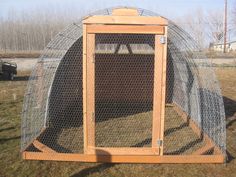 an outdoor chicken coop in the grass