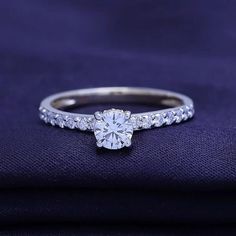 a diamond ring on top of a purple cloth