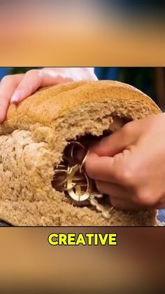 a person holding a piece of bread with the word creative written on it in front of them