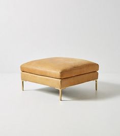 a small footstool sitting on top of a white floor next to a wall