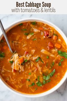 a bowl of chicken and vegetable soup with a spoon in it on a marble surface