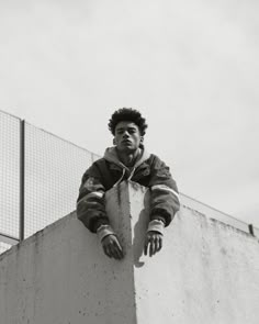 a man standing on top of a cement wall