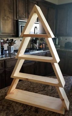 a wooden christmas tree sitting on top of a kitchen counter