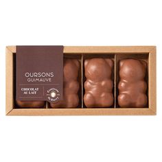 three chocolates in a cardboard box with a brown label on the top and bottom