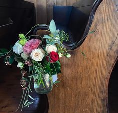 a vase filled with flowers sitting on top of a wooden table next to a piano