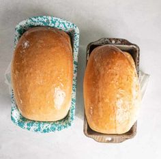 two loafs of bread sitting on top of a blue and white tray next to each other