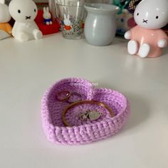 there is a crocheted heart shaped ring holder on the table