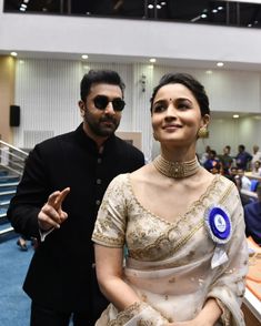 a man and woman standing next to each other in front of an audience at a convention