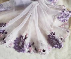 purple and white embroidered fabric with flowers on it