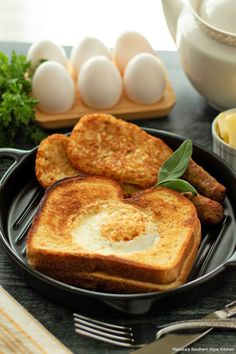 two pieces of toast on a plate with eggs and sausages next to it,