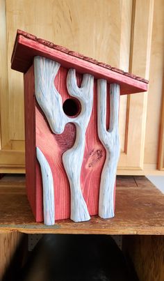 a birdhouse made out of wood and painted red