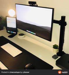 a computer monitor sitting on top of a desk next to a keyboard, mouse and headphones