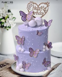 there is a purple cake with butterflies on it