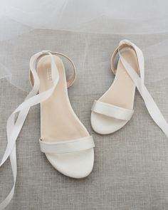 the bride's shoes are all white and have straps on each shoe, which is tied