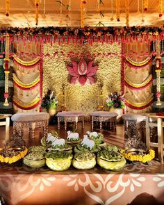 an elaborately decorated stage with many plates and bowls on the table in front of it