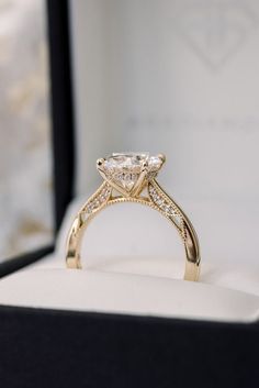 an engagement ring in a gift box with the diamond set on it's side