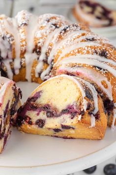 a blueberry bunt cake is on a plate with one slice cut out and ready to be eaten