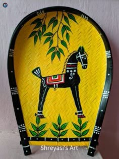 a decorative plate with a horse painted on it's side and leaves in the background