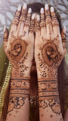 a woman's hands covered with henna