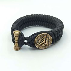 Follow Odin with Valknut paracord bracelet Valknut is symbol of weaving of nine worlds in Norse Mythology. This is custom hand woven bracelet made from paracord 550 (strong rope). The mens wristband with handmade beads made from Italian bronze solid. This bracelet is perfect gift option for Norse, Nordic or Viking style jewelry lovers, it can be used for men or women.. Description of Valknut bracelet: Material: Italian bronze solid (88 % Copper, 12% Tin) and Paracord 550 The bracelet is made for Durable Black Paracord Bracelets, Handmade Black Braided Bracelets For Outdoor, Handmade Black Paracord Braided Bracelet, Viking Symbol, Paracord Armband, Bracelet Viking, Viking Symbols, Woven Bracelet, Viking Style