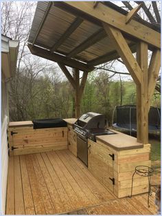 an outdoor kitchen with grill and seating area