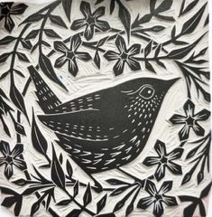 a black and white paper cut bird sitting in a tree