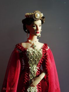 a mannequin wearing a red dress and headpiece with pearls on it's neck