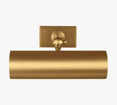 a gold toilet roll holder on a white background with a light fixture in the middle