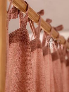 pink curtains hanging from a wooden rod