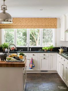 a large kitchen with white cabinets and black counter tops, along with an island in the middle