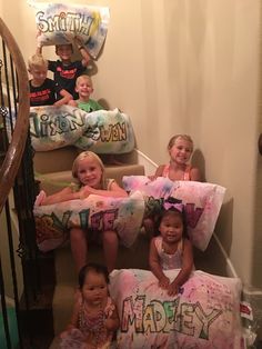 several children sitting on the stairs with pillows that say happy