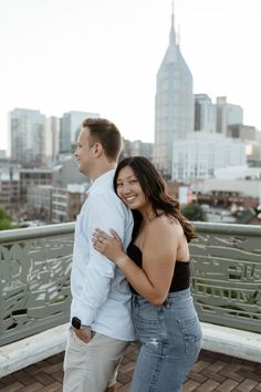 a man and woman standing next to each other on a bridge