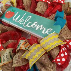 a welcome sign on a burlock wreath