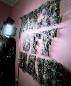 a pink wall with black and white letters on it