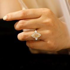 a woman's hand with a yellow and white diamond ring