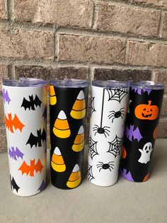 three different colored tumbles with halloween designs on them, one is black and the other is white