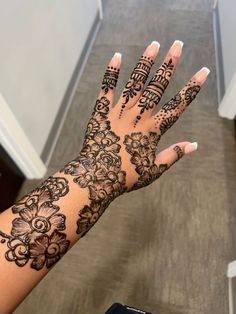 a woman's hand with henna tattoos on it