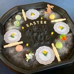 a black tray with white plates and utensils in the shape of an easter scene