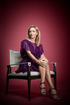 a woman sitting on top of a chair with her legs crossed