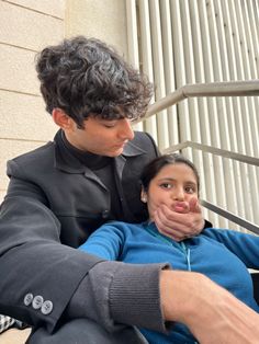 a man sitting next to a woman on top of a bench