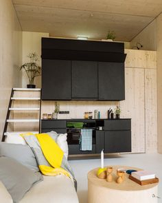 a living room filled with furniture next to a kitchen