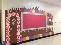 a bulletin board with candy canes on it in a school hallway decorated for christmas