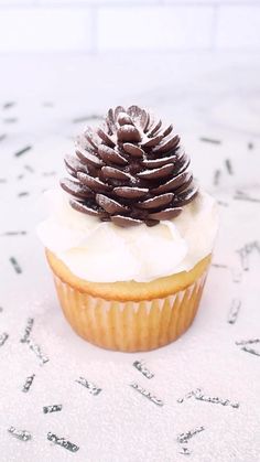 a cupcake with frosting and pine cone decorations